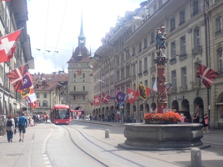 12:36　路面電車、間隔を置いて意匠の凝ったポールが目印の水場、両脇にはアーケード